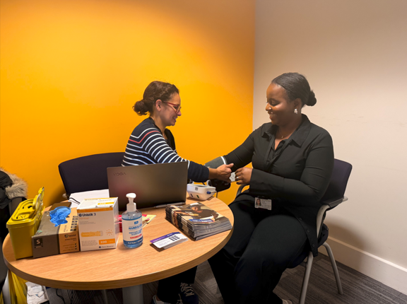 A person having their blood pressure checked during a workplace health check.